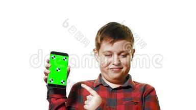 开朗的男孩手里拿着一部智能手机，手里拿着一个绿色的屏幕，屏幕上显示着一个手指。